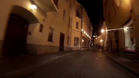Conduciendo-De-Noche-Por-La-Calle-Estrecha-Del-Casco-Antiguo-De-Vilnius