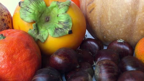 A-nice-view-of-autumn-fruits-such-as-pomegranate,-pumpkin,-chestnuts,-persimmon-and-oranges