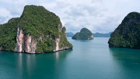 Drone-footage-of-islands-in-Thailand-with-limestone-rock-formation-sticking-out-of-the-water-and-the-ocean-in-background-8