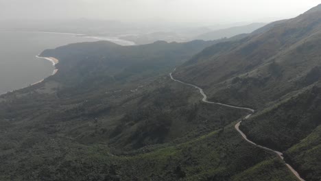 Aerial-drone-shot-of-twisting-road-along-coastal-mountain-pass-on-hai-van-pass-in-vietnam-countryside