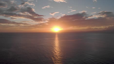 Luftaufnahme-Eines-Lebendigen,-Wunderschönen-Sonnenuntergangs-über-Riesigen-Klippen-In-Uluwatu-Bali-Mit-Tiefblauen-Wellen-Am-Fuße-Des-Ozeans