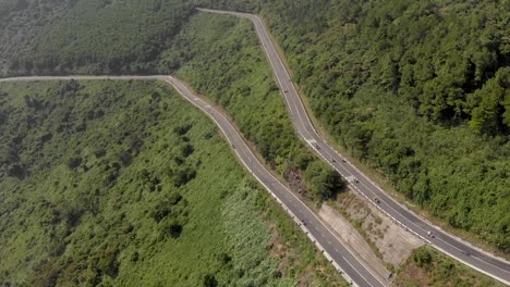 Revolving-aerial-drone-shot-of-twisting-hairpin-road-upon-high-mountain-pass-roads-on-Hai-Van-Pass-road-trip-in-Vietnam