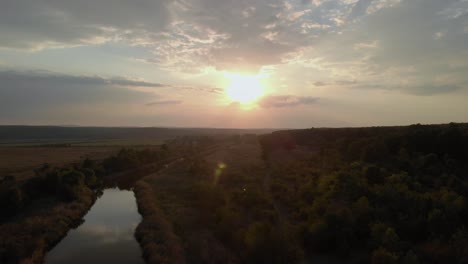 Aerial-shot-of-river-in-green-valley-at-sunset-3