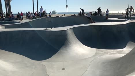 Local-skater-boarders-and-skating-professionals-jumping-off-rails-and-practicing-their-tricks-at-the-iconic-Venice-Beach-Skatepark