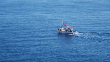 Volle-Aufnahme,-Touristenboot-Mit-Einer-Türkeiflagge,-Die-Das-Blaue-Meer-In-Antalya,-Türkei-Segelt