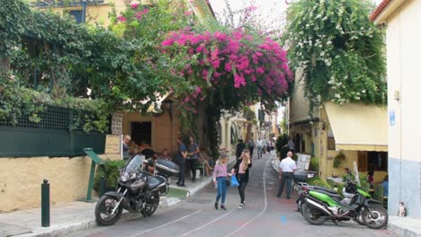 Turistas-Caminando-En-Una-Calle-Angosta-En-La-Tradicional-Ciudad-De-Plaka-Cerca-De-La-Acrópolis-En-Atenas,-Grecia