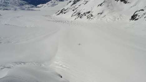 4K-Drohnenaufnahmen-Eines-Winzigen-Basislagers-Aus-Zelten-Auf-Einem-Riesigen-Weitläufigen-Gletscher