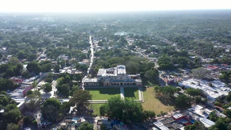 High-aerial-push-in-to-the-Convent-de-San-Bernardino-in-Valladolid,-Yucatan,-Mexico-in-early-morning
