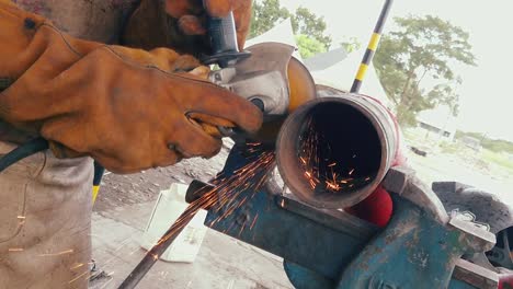 Blacksmith-or-welder-professional,-smooths-steel-and-iron,in-extreme-slow-motion,to-make-the-surface-smooth