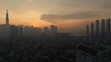 Right-to-left-panoramic-dolly-drone-shot-at-Five-o'clock-in-the-morning-over-city-with-silhouette-of-massive-high-rise-buildings