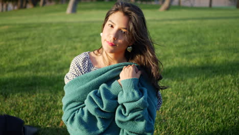 Close-up-of-a-pretty-hispanic-woman-trying-to-get-warm-and-cozy-with-her-sweater-in-cold-season-windy-weather