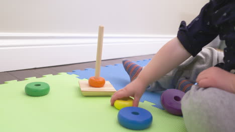 Baby-boy-playing-with-colorful-stacking-rings