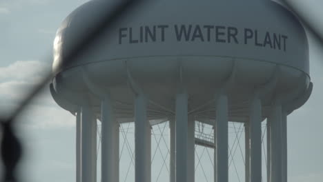 The-camera-title-up-to-reveal-the-top-of-the-Flint-Water-Tower-at-the-Flint,-Michigan-Water-Plant
