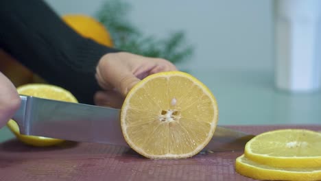 Mujer-Cortando-Limón-Amarillo-En-La-Tabla-De-Cortar-Closeup-Cámara-Lenta