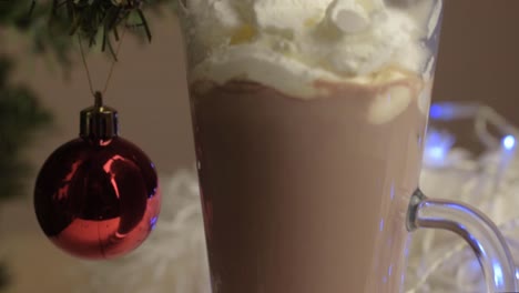 Pouring-whipped-cream-onto-hot-chocolate-drink-at-Christmas