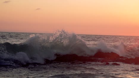 Super-slow-motion-wave-crashing-on-a-reef-in-front-of-sunset-in-California