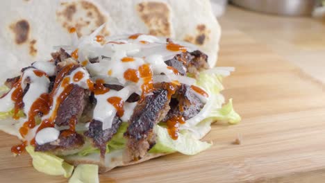 Slow-Motion-Slider-Shot-of-Folding-a-Naan-Bread-Over-a-Doner-Kebab-at-Home-in-the-Kitchen