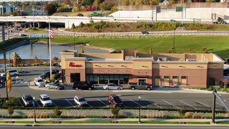 Aerial-of-Chick-fil-A-fast-food-drive-thru-beside-busy-highways,-Eat-More-Chicken