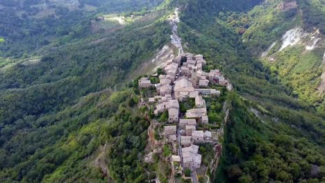 Civita-di-Bagnoregio-town-in-Tuscany-Italy-with-eroding-side-cliffs,-Aerial-drone-flyover-back-shot