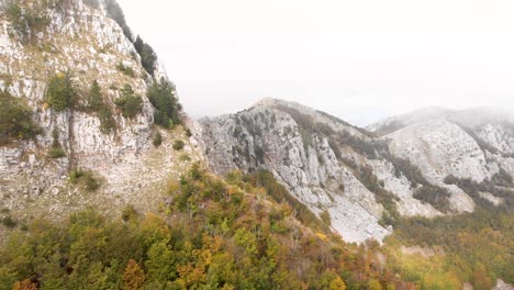 Aerial-footage-of-the-Lovcen-National-Park-and-Black-Lake-with-amazing-fall-colors-everywhere-with-low-clouds