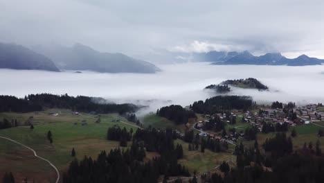 Aerial-Dolly-Back-View-Over-Arvenbuel-In-Switzerland-With-Dramatic-Mist