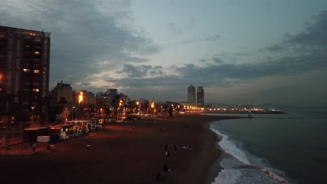 Hohe-Luftdrohnenaufnahme,-Die-Nachts-über-Den-Schönen-Barceloneta-strand-In-Barcelona-Fliegt