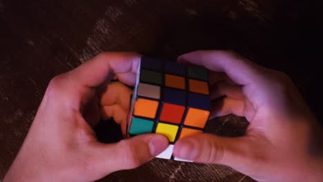 Junger-Mann,-Der-Versucht,-Einen-Rubikwürfel-Auf-Einem-Holztisch-Zu-Lösen-4
