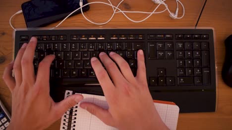 Young-man-is-writting-a-text-on-his-computer-using-a-keyboard-1