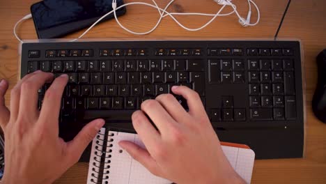Young-man-is-writting-a-text-on-his-computer-using-a-keyboard-2