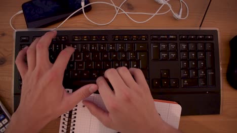 Young-man-is-writting-a-text-on-his-computer-using-a-keyboard-3