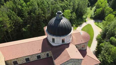 Backward-moving-aerial-of-catholic-shrine-of-our-Lady-of-Guadalupe-in-La-Crosse-Wisconsin,-surrounded-by-pure-nature