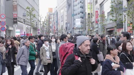 Pedestrians-crossing-Shibuya-Crossing-in-downtown-Tokyo,-Japan