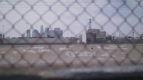 Pulling-focus-looking-through-a-fence-towards-downtown-LA-on-a-gloomy-day