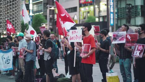 Japan-stand-Mit-Hongkong---Japaner,-Die-Banner-Und-Flaggen-Von-Japan-Und-Hongkong-Halten,-Um-Ihre-Unterstützung-Beim-Solidaritätsprotest-In-Tokio-Zu-Zeigen---Breite-Zeitlupenaufnahme