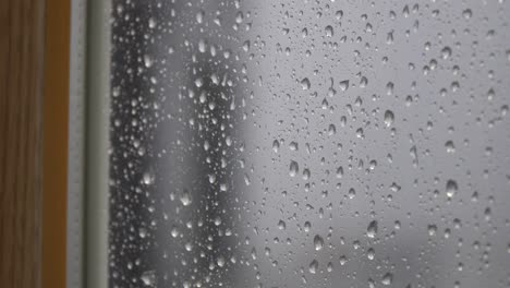 Regentropfen,-Die-Auf-Die-Verschwommene-Fensteraußenseite-Tropfen---Nahaufnahme