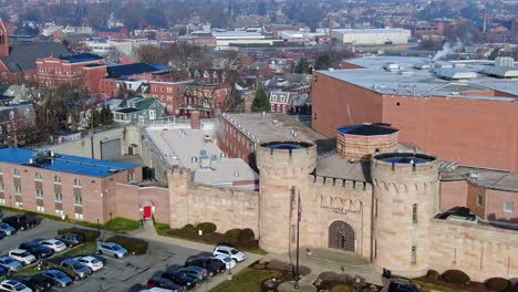 Medieval-towers-and-walls-of-Lancaster-County-Prison-with-modern-cell-block-in-the-background,-aerial-view-of-correctional-facility-in-America