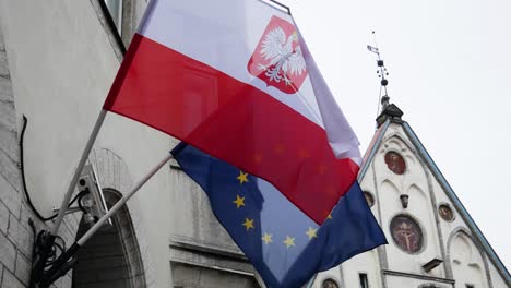 European-Union-and-Poland-National-flags-are-waving-because-of-light-wind-in-Tallinn-old-town