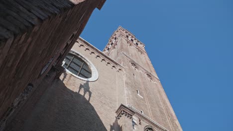 Revealing-close-up-of-church-bell-tower-on-Basilica-di-Frari-on-a-sunny-day-in-Venice