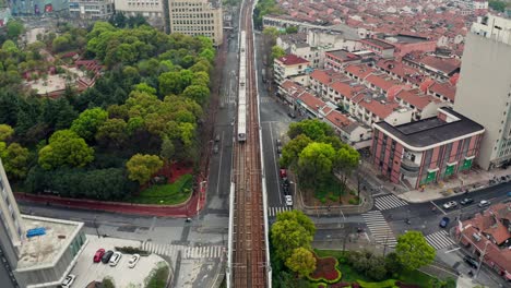 4k-Aerial-shot-of-subway-train-going-into-tunnel-covered-with-green-grass