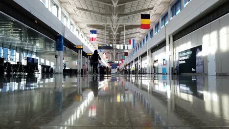 Das-Fast-Menschenleere-Flughafenterminal-Hat-Nur-Wenige-Menschen,-Die-Zu-Fuß-Gehen,-Um-Flüge-Zu-Erwischen-Oder-An-Ihrem-Ziel-Anzukommen