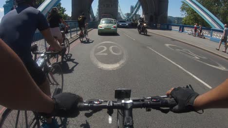 POV-Of-Cyclists-Going-Across-Tower-Bridge,-London-Going-Past-Traffic