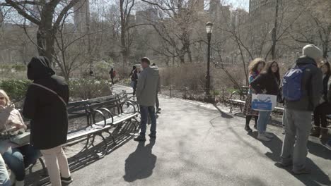 Point-of-view-shot-walking-down-a-busy-pedestrian-path-in-Central-Park,-Manhattan,-on-a-bright-fall-day