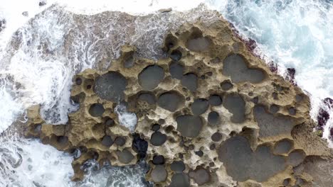 Volcanic-built-coastline-of-Nusa-Penida-island-near-Broken-beach-hit-by-strong-waves,-Aerial-top-view-shot
