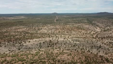 Forward-moving-drone-shot-of-a-dry-game-farm-during-drought-near-Okahandja,-Namibia