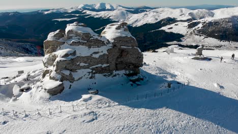 Aerial,-orbit,-drone-shot-around-the-sphinx-rock-formation,-on-the-top-of-the-southern-Carpathians,-on-a-sunny-winter-day,-in-the-Bucegi-Natural-Park,-Romania