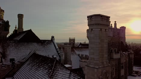 Türme-Und-Ziegeldach-Einer-Malerischen-Burg-Bei-Sonnenuntergang,-Drohnenrutsche-Rechts