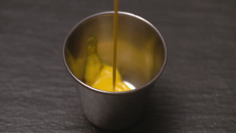 Pouring-mustard-into-a-stainless-steel-ramekin-for-dipping