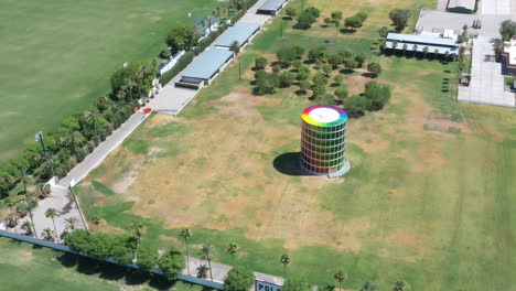 Empty-and-desolate-Empire-polo-club-colorful-round-tower-building-at-Coachella-Valley-Music-Arts-Festival,-covid-19-pandemic,-above-circle-aerial