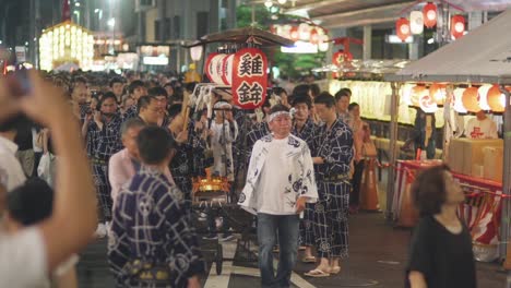 Kyoto,-Japón---Una-Gran-Multitud-De-Personas-Presenciando-El-Desfile-De-Hiyori-Kagura-Durante-El-Festival-Yoiyama-En-El-Festival-Gion-Matsuri-Por-La-Noche---Plano-Medio