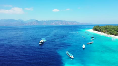 Cruise-ships-and-other-small-boats-sitting-on-the-surface-of-crystal-clear-blue-waters-of-a-tropical-island
